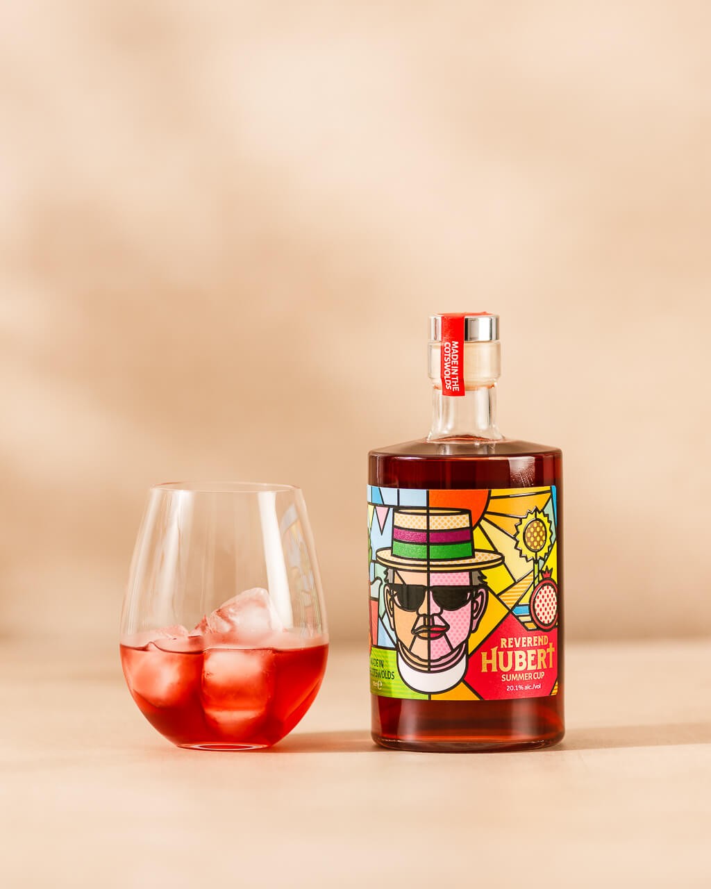 Bottle of Reverend Hubert Summer Cup with glass of Summer Cup neat over ice